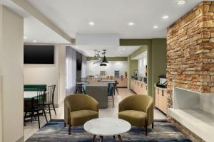 a living room with a table and chairs and a kitchen at Fairfield Inn & Suites Indianapolis Airport in Indianapolis
