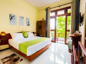 a bedroom with a bed and a large window at Mashmellow Resort and Spa in Galle