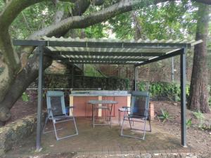 two chairs and a table under a tree at Rincón de la Luna in Tepoztlán