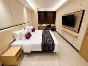a hotel room with a large bed and a flat screen tv at Prime Plaza Hotel Mataram in Mataram