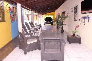 a group of chairs sitting on a porch with a car at Pousada Familiar Encanto da Chapada in Carolina