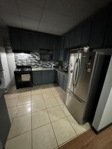 a kitchen with blue cabinets and a stainless steel refrigerator at Casa No6 Ascot in Carapo +6 photos