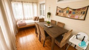 a dining room with a table and chairs and a bed at Driftwood at Blacksmiths in Blacksmiths
