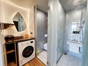 a bathroom with a washing machine and a sink at Udo Chano Village in Jeju +19 photos