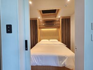 a bedroom with a large bed with white sheets at Udo Chano Village in Jeju