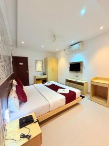 a bedroom with a large bed and a television at The Berry House in Satara