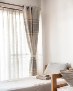 a bedroom with a bed and a window with curtains at Ethico Retreat Formely Five14 BnB in Pātan