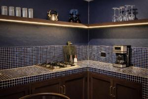 a blue tiled kitchen with a stove and a microwave at Casa UMA in San Miguel de Allende +29 photos