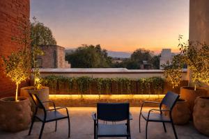 a patio with chairs and a view of the sunset at Casa UMA in San Miguel de Allende