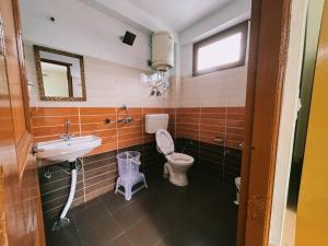 a bathroom with a toilet and a sink at Non Stop Cafe Hostel & Stay in Manāli +93 photos