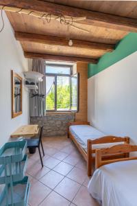 a bedroom with a bed and a desk and a window at La Vrata Gialla in Taipana