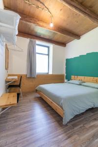 a bedroom with a large bed and a desk at La Vrata Gialla in Taipana