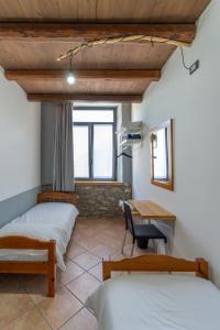 a room with two beds and a table and a desk at La Vrata Gialla in Taipana +31 photos