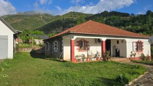 a small white house with a mountain in the background at Guesthouse Lika in Shkozë +35 photos