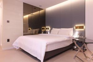 a bedroom with a large white bed and a mirror at Seocho JS Hotel in Seoul