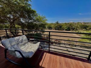 a chair sitting on a deck with a view of a field at A Frame house Perú in Lambayeque