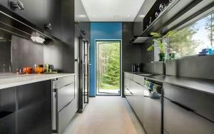 a kitchen with black walls and a large window at Architect Villa By Cliff Bathing In High Coast in Härnösand