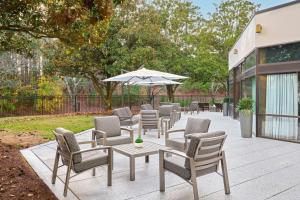 a row of tables and chairs with an umbrella at Marriott Raleigh Durham Research Triangle Park in Durham