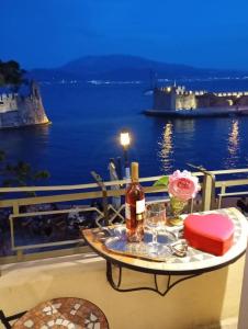 a table with a bottle of wine on a balcony at Casa da Sogno Elegant Studio in Nafpaktos