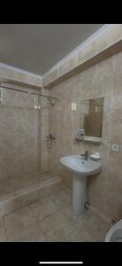 a bathroom with a sink and a shower and a tub at Танхаус Коттедж in Bosteri
