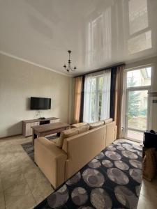 a living room with a couch and a table at Танхаус Коттедж in Bosteri