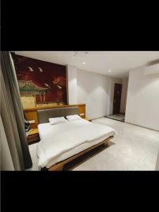 a bedroom with a bed and a painting on the wall at LL Palace in Hinganghāt