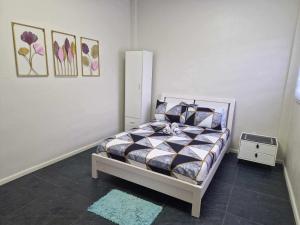 a bedroom with a bed and paintings on the wall at S & R Homes in Tacloban