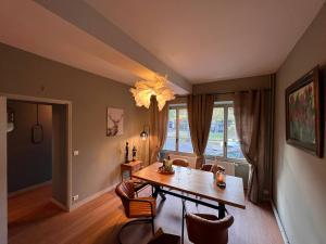 a dining room with a table and chairs and a window at 32-La Place To Be in Senlis