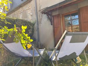 two chairs sitting in the grass in front of a house at 32-La Place To Be in Senlis