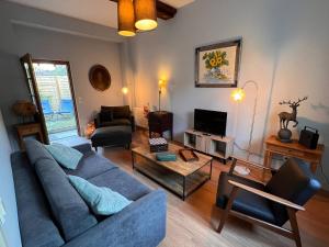 a living room with a blue couch and a tv at 32-La Place To Be in Senlis
