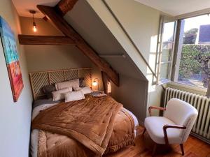 a bedroom with a large bed and a chair at 32-La Place To Be in Senlis