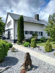 a house with a rock in the front yard at Dreiflüsse Appartement - Traumgarten mit Grill und Pavillon, WLAN, Küche und Parkplatz in Salzweg