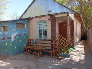 a bench sitting outside of a house with a building at Guest House Aruuke in Naryn +27 photos
