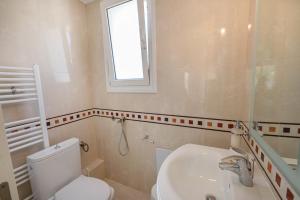 a bathroom with a toilet and a sink and a window at Sunray Poros in Poros +18 photos