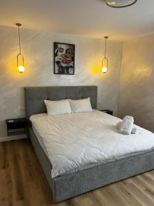 a bedroom with a large bed with two lights at 7 min walking to airport in Otopeni