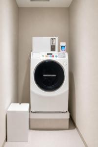 a white washing machine sitting in a room at KIORI Exec Muromachi in Kyoto