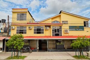 ein gelbes Gebäude, vor dem ein Motorrad geparkt war in der Unterkunft Hotel plata inn in Villavicencio