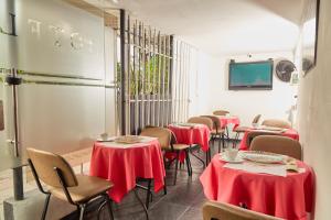 ein Restaurant mit Tischen und Stühlen mit roten Tischdecken in der Unterkunft Hotel plata inn in Villavicencio
