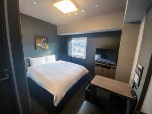 a hotel room with a bed and a television at Hotel Route-Inn Tsuyama Ekimae in Tuyama +30 photos