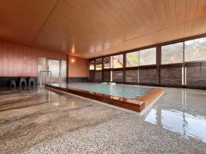 a large swimming pool in a large room with a large window at 秘湯花文 in Myoko