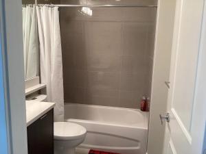 a bathroom with a toilet and a tub and a sink at 温哥华列治文别墅民宿33 in Richmond