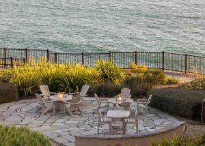 a patio with tables and chairs next to the water at Pacific Point Resort in Pismo Beach +2 photos