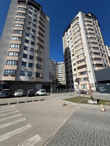 two tall buildings next to a street with cars at RentDay Botanica in Chişinău