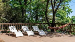 four chairs and a hammock on a deck at Yangyang Little Forest Pension in Yangyang