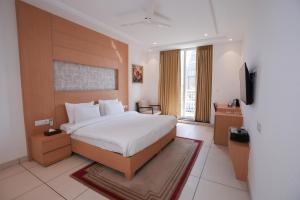 a hotel room with a bed and a television at Annekaa Heights in Vrindāvan