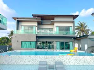 a building with a swimming pool in front of a house at Sky Beach Pool Villa Chanthaburi 2 in Laem Sing
