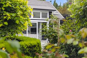 a house with a white door and bushes at Treghan Luxury Lodge in Kerikeri