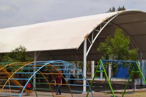 a building with a white canopy and a playground at Casa Versalles in Aguascalientes