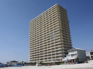 a tall building on the beach next to a beach at Seychelles Resort by Panhandle Getaways in Panama City Beach