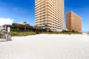 a sandy beach with two tall buildings in the background at Seychelles Resort by Panhandle Getaways in Panama City Beach